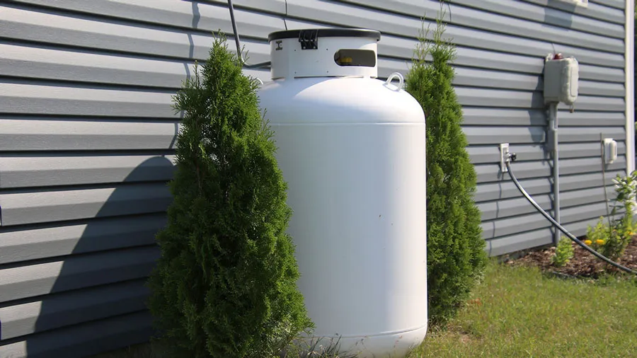 A propane tank set beside a home to fuel a standby generator